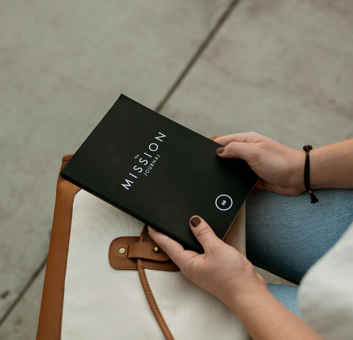 woman holding black Mission book